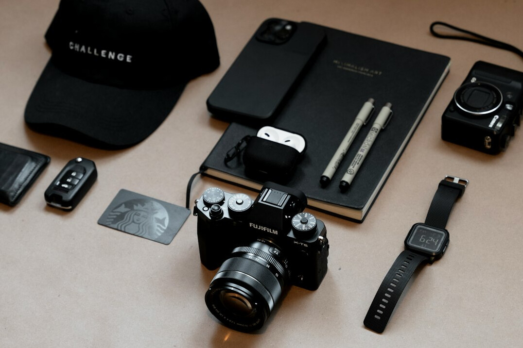 Flat lay of camera equipment and notebook